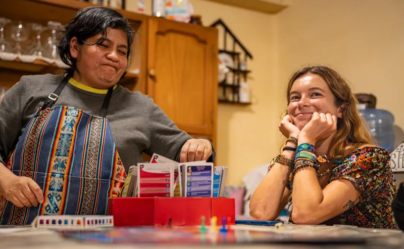 Teacher and student laughing over a board game